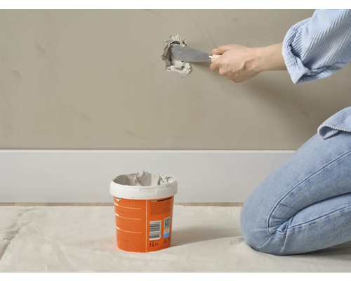 Reparatie van een muur met vulmiddel en een plamuurmes