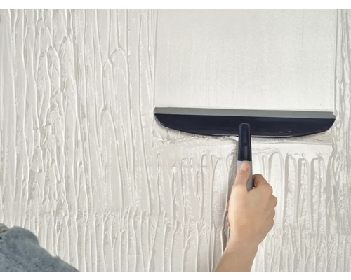 Hand met vlakspaan bewerkt wandplamuur