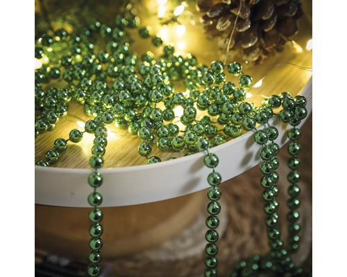 Decoratie met groene kralenkettingen, lichtsnoer en dennenappel