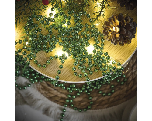 Decoratie met dennenappels, lichtsnoer en groene kralenslinger