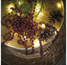 Decoratie met kerstballen, dennenappels, lichtjes en dennenappels op een tafel