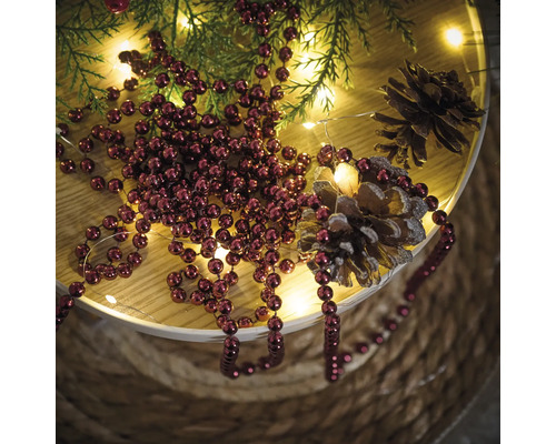 Decoratie met kerstballen, dennenappels, lichtjes en dennenappels op een tafel