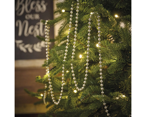 Kerstboom met zilverkleurige kralenketting als decoratie