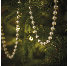 Zilverkleurige kralenketting als boomversiering in een kerstboom