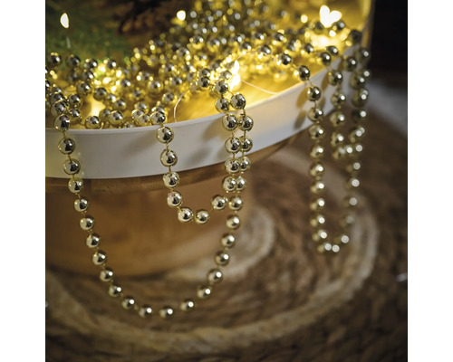 Goudkleurige kralenketting ter decoratie in een schaal