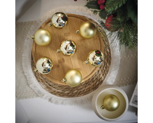 Decoratieve gouden kerstballen op houten dienblad