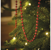Kerstboom versierd met rode kralenslinger