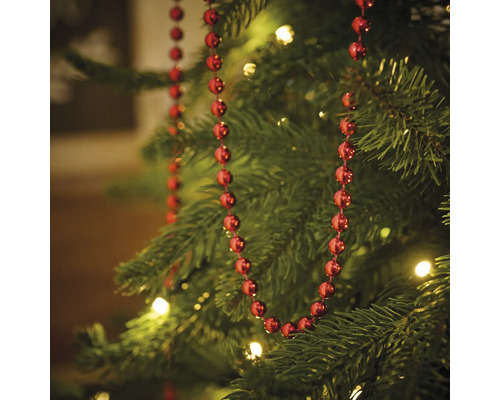 Kerstboom versierd met rode kralenslinger