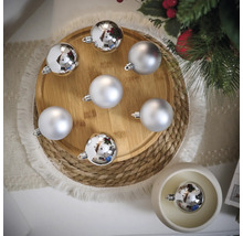 Decoratieve zilverkleurige kerstballen op een houten bord