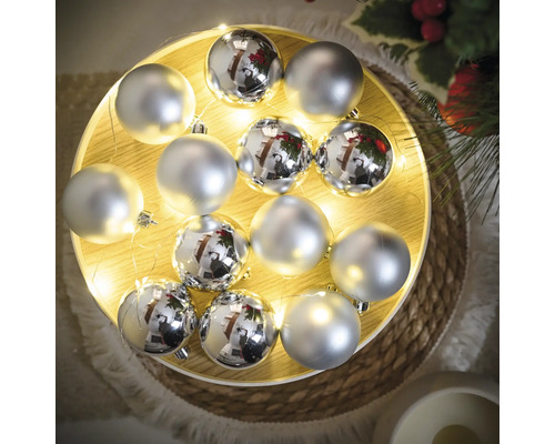 Decoratie met zilverkleurige kerstballen op een verlicht dienblad