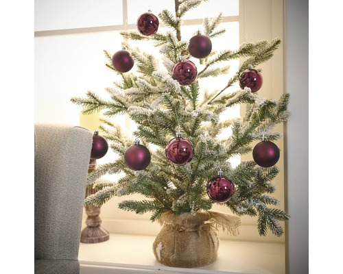 Decoratieve kerstboom met boomversiering en jute zak