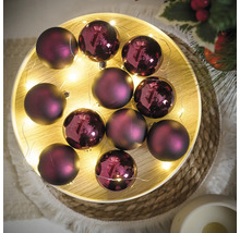 Decoratieve paarse kerstballen met lichtsnoer op een dienblad