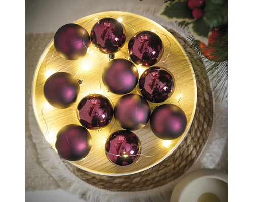 Decoratieve paarse kerstballen met lichtsnoer op een dienblad