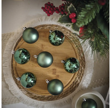 Decoratieve groene kerstballen op een houten bord