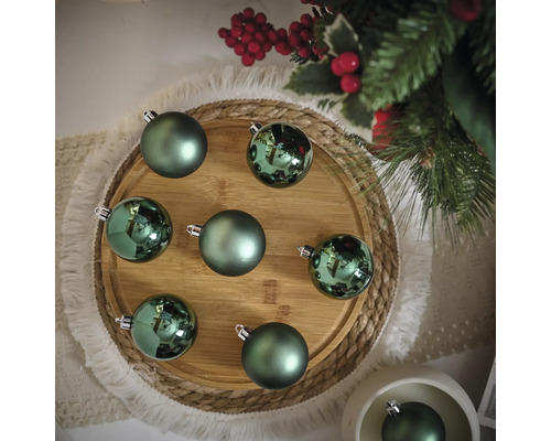 Decoratieve groene kerstballen op een houten bord