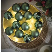 Decoratieve groene kerstballen op een verlicht houten dienblad voor feestelijke decoraties