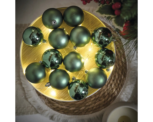 Decoratieve groene kerstballen op een verlicht houten dienblad voor feestelijke decoraties