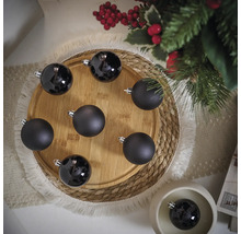Decoratieve zwarte kerstballen op een houten bord