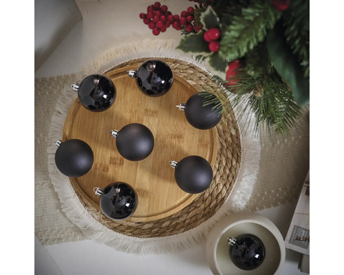 Decoratieve zwarte kerstballen op een houten bord
