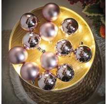 Decoratieve roze kerstballen op een verlicht dienblad.