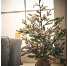 Gedecoreerde miniatuurkerstboom met ballen in een jutezak