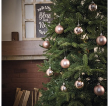 Versierde kerstboom met kerstballen voor een open haard
