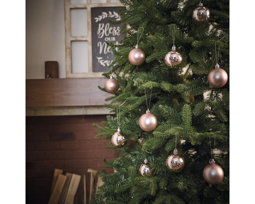 Versierde kerstboom met kerstballen voor een open haard