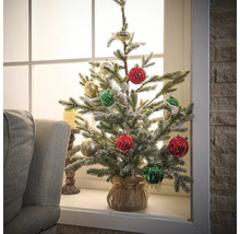 Gedecoreerde kunstkerstboom op vensterbank