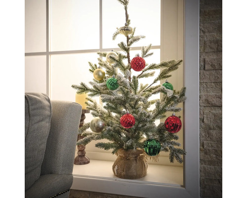 Gedecoreerde kunstkerstboom op vensterbank