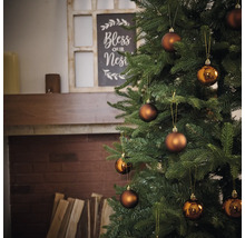 Versierde kerstboom met ballen voor open haard