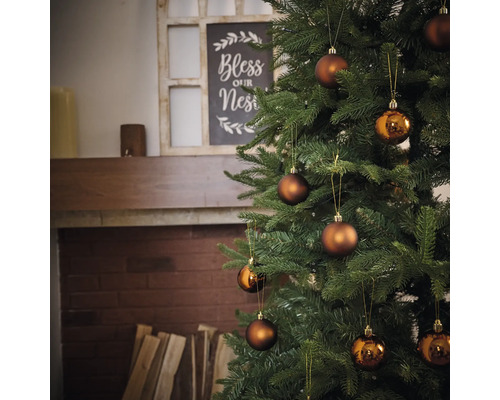 Versierde kerstboom met ballen voor open haard