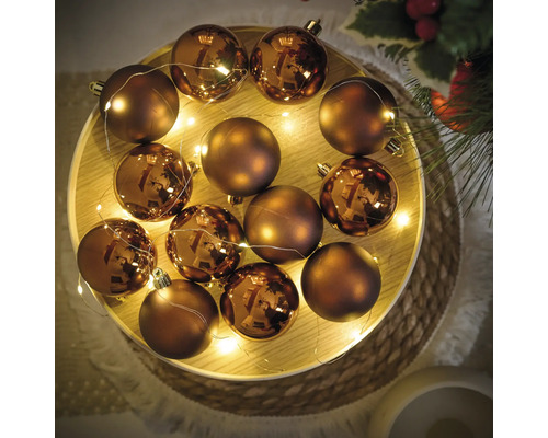 Decoratieve schikking van kerstballen en een lichtsnoer op een dienblad.