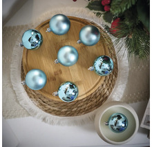 Decoratieve scène met blauwe kerstballen op een houten bord en een gevlochten onderzetter