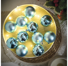 Decoratieve, blauwe kerstballen met lichtketting op een schaal