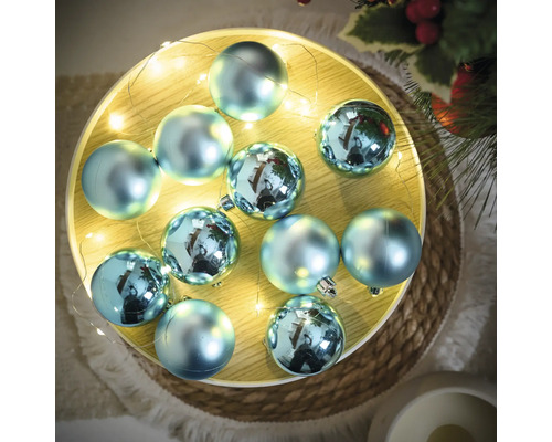 Decoratieve, blauwe kerstballen met lichtketting op een schaal