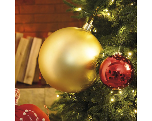 Close-up van een kerstboom met gouden en rode kerstballen en lichtjes