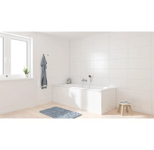 Lichte badkamer met bad, raam en handdoek