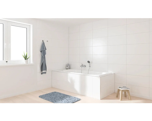 Lichte badkamer met bad, raam en handdoek