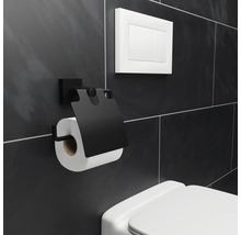 Zwarte toiletpapierhouder met rol toiletpapier aan badkamermuur