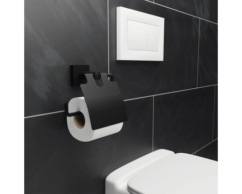 Zwarte toiletpapierhouder met rol toiletpapier aan badkamermuur