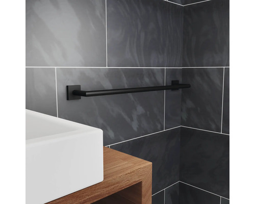 Zwarte handdoekhouder in badkamer met wastafel en grijze tegels