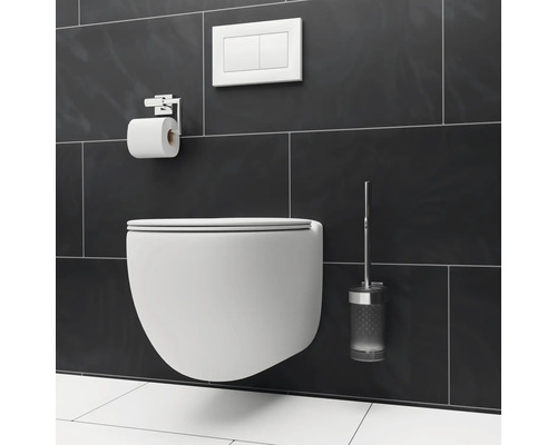 Wandhangend toilet met toiletpapierhouder, bedieningspaneel en toiletborstel voor een donkere tegelachtergrond.