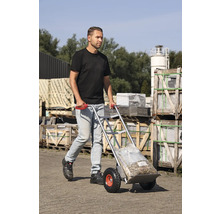 Man vervoert zakgoed met een steekwagen buitenshuis