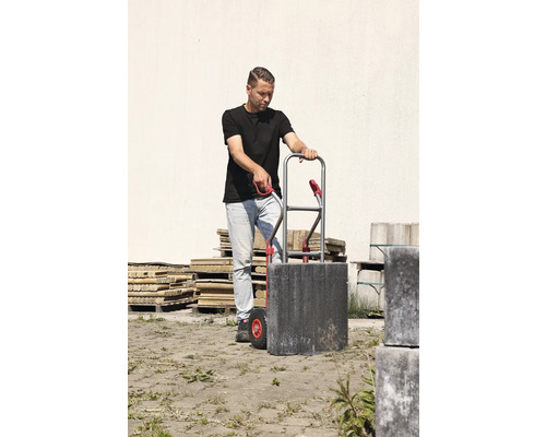 Man vervoert straatstenen met een steekwagen.