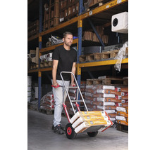 Man transporteert zakgoed met een steekwagen in een magazijn.