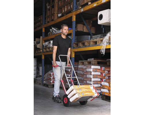 Man transporteert zakgoed met een steekwagen in een magazijn.