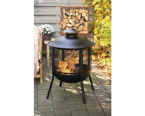 Vuurkorf met vonkenvanger en houtopslag in de tuin