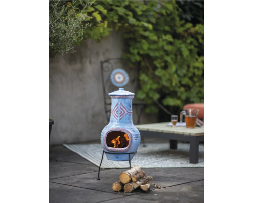 Decoratieve terracotta tuinhaard met hout op een terras