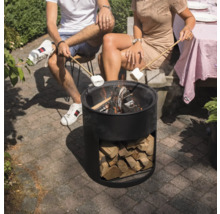 Mensen zitten rond een vuurkorf en houden marshmallows boven de vlammen