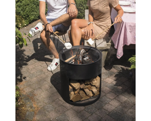 Mensen zitten rond een vuurkorf en houden marshmallows boven de vlammen